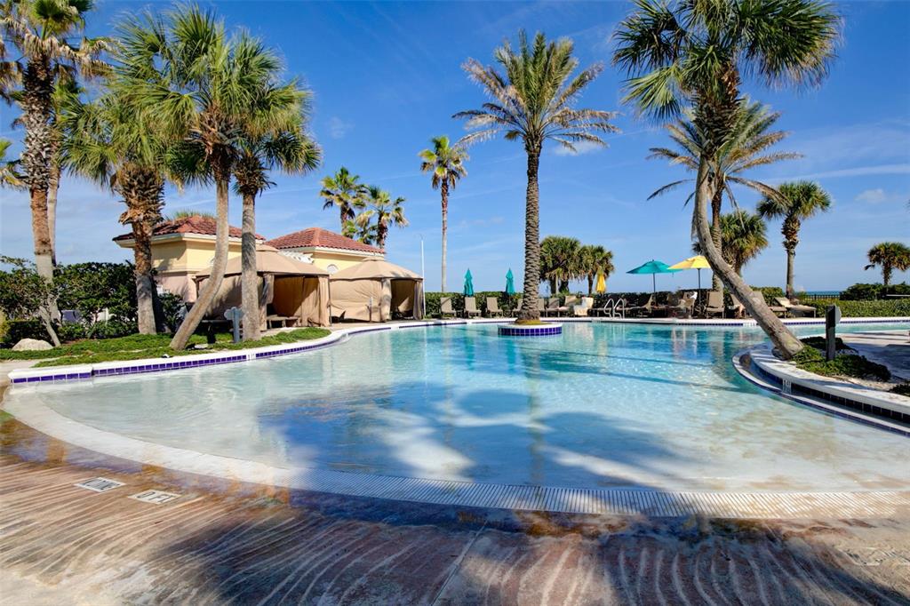 35 Ocean Crest Way, Unit 1124 Palm Coast, FL 32137 - Photo 59 of 81 a view of a swimming pool with a yard and palm trees