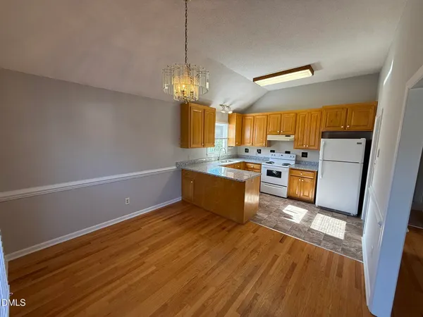 a kitchen with stainless steel appliances a stove a refrigerator and a view of living room