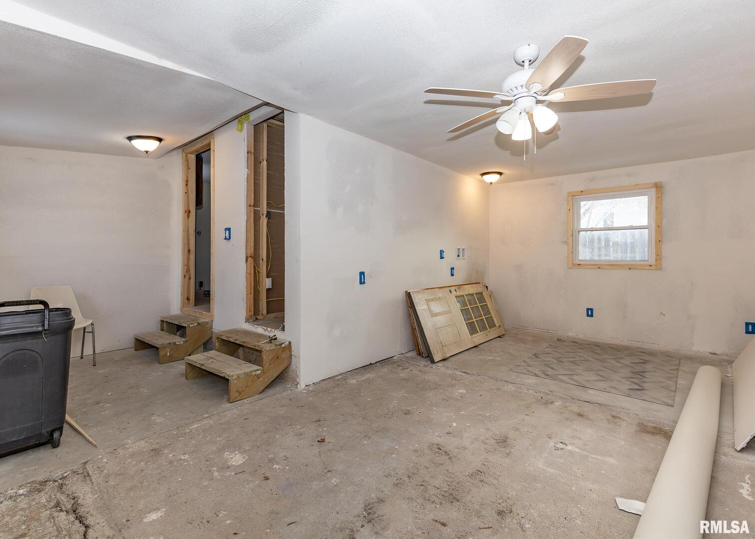 513 3rd Street Camanche, IA 52730 - Photo 5 of 13 a view of a room with gym equipment and a chandelier