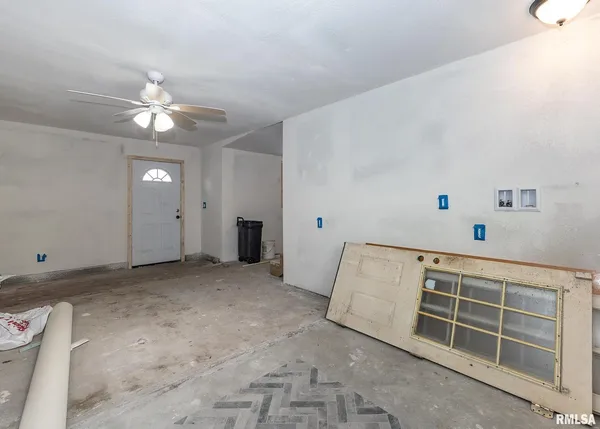 a view of a livingroom with a ceiling fan and wooden cabinets