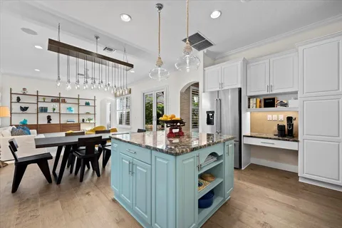 a living room with furniture kitchen view and a large window