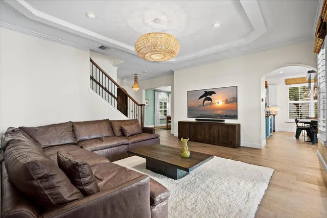 a dining room with wooden floor a chandelier a wooden table and chairs