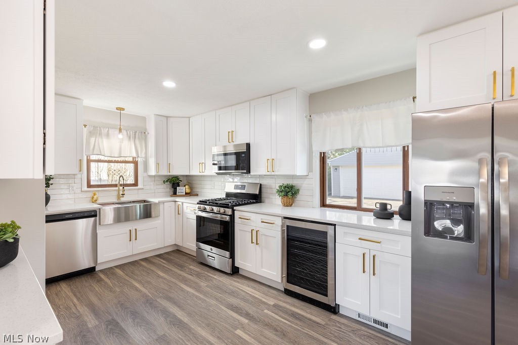 9620 David Road Garfield Heights, OH 44125 - Photo 10 of 36 Kitchen with beverage cooler, sink, stainless steel appliances, hardwood / wood-style flooring, and pendant lighting