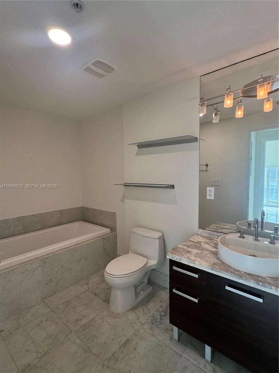 244 Biscayne Boulevard, Unit 1405 Miami, FL 33132 - Photo 7 of 13 a bathroom with a sink a toilet and bathtub