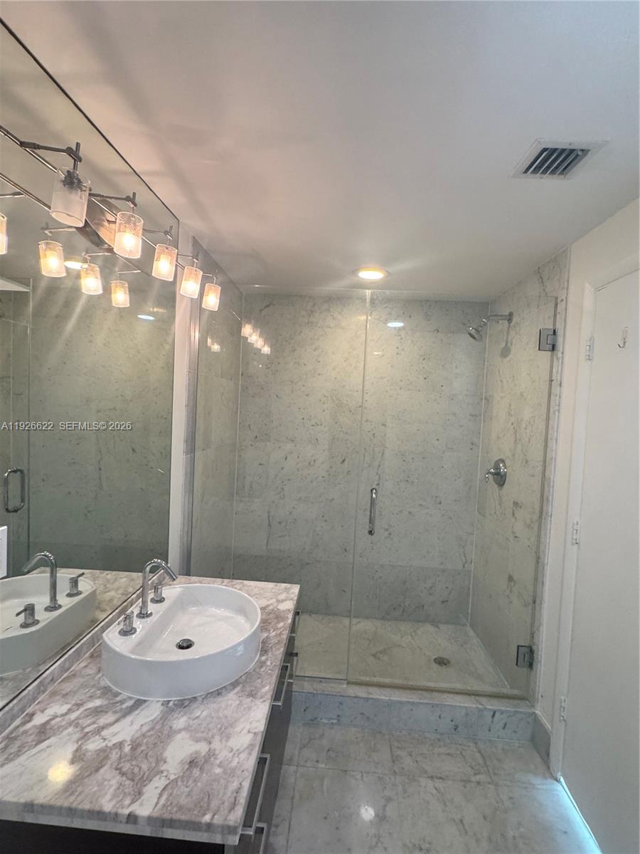 244 Biscayne Boulevard, Unit 1405 Miami, FL 33132 - Photo 8 of 13 a bathroom with a sink and shower