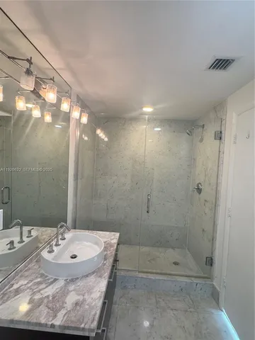 a bathroom with a sink and shower