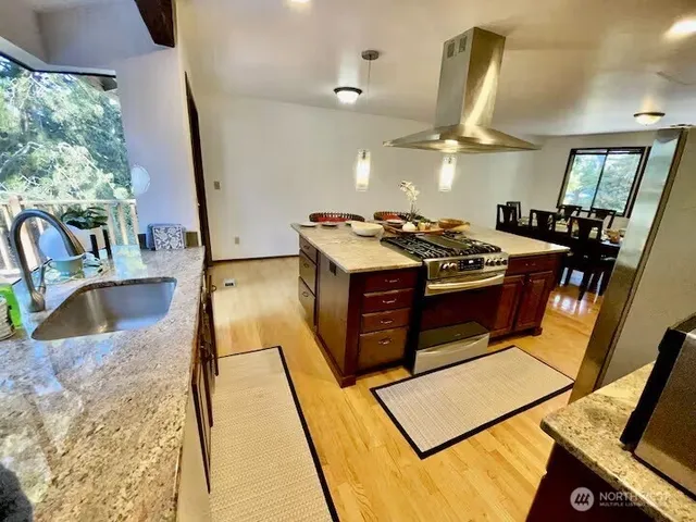 a kitchen with stainless steel appliances granite countertop a stove and a sink