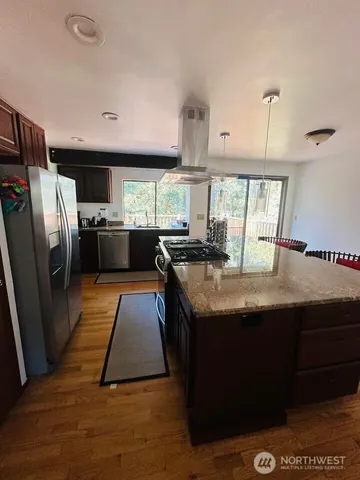 a kitchen with stainless steel appliances granite countertop a sink a stove and a refrigerator