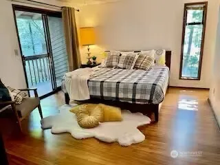 a bedroom with a bed window and wooden floor