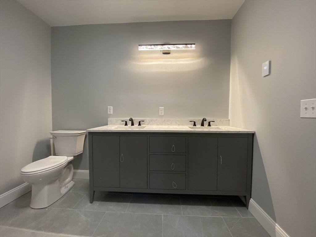 855 County Street, Unit 2 Attleboro, MA 02703 - Photo 23 of 27 a bathroom with a sink vanity and a toilet