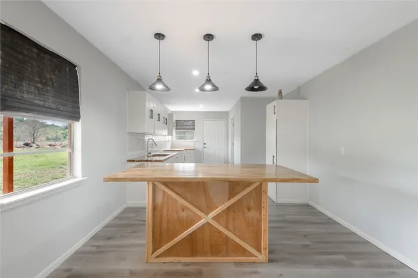a room with table chairs and window