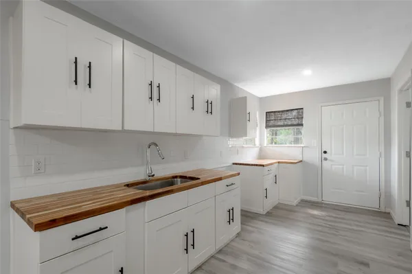 a kitchen with sink cabinets and wooden floor