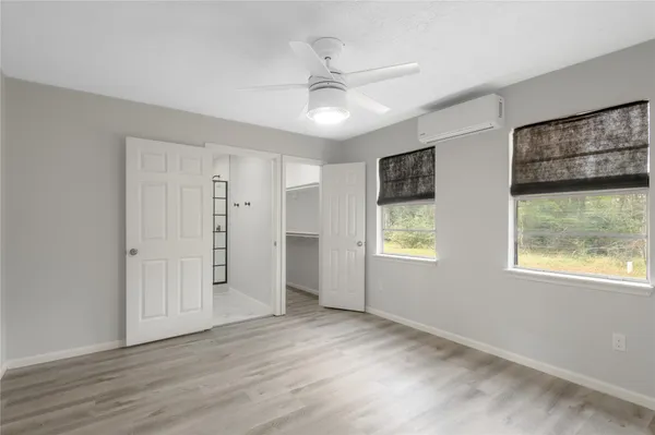 a view of an empty room with a window and wooden floor