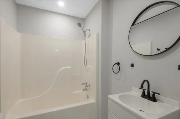 an empty room with wooden floor chandelier fan and windows