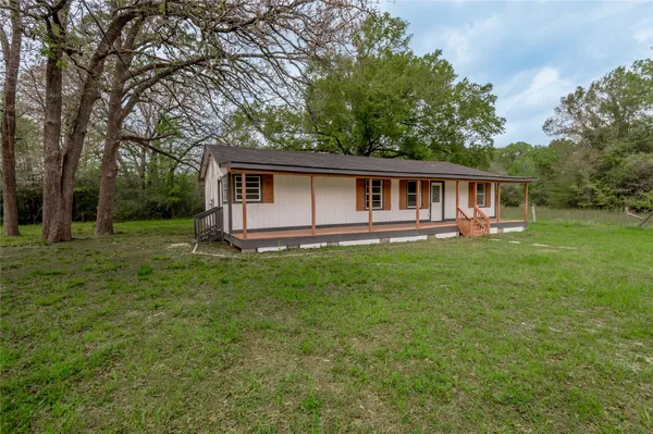 a view of a house with backyard and trees
