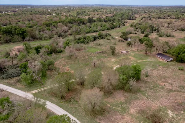 an aerial view of residential houses with outdoor space and trees