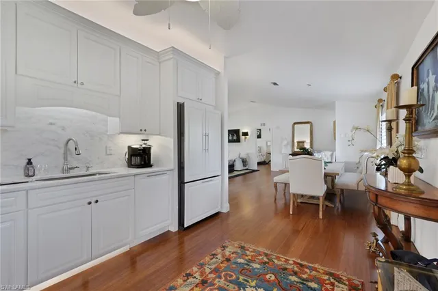 a kitchen with stainless steel appliances sink refrigerator dining table and chairs