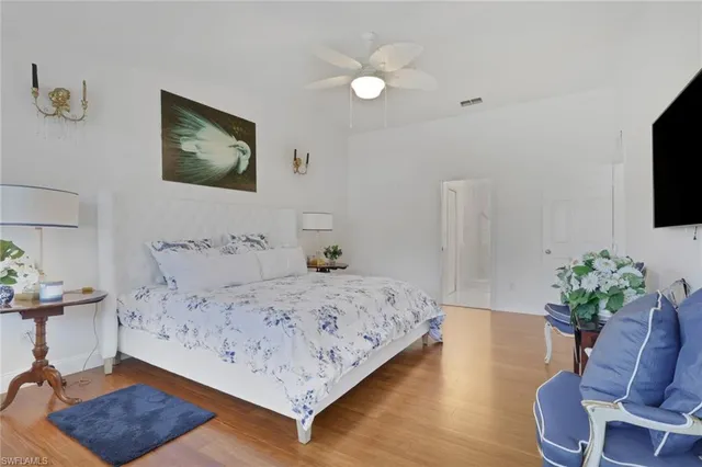 a bedroom with a bed window potted plant and a chair