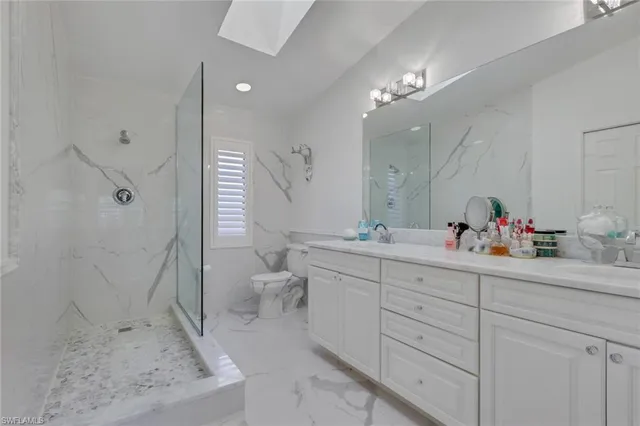 a spacious bathroom with a sink mirror vanity and toilet