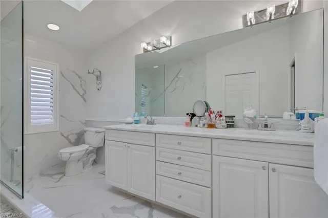 a bathroom with a double vanity sink mirror and toilet