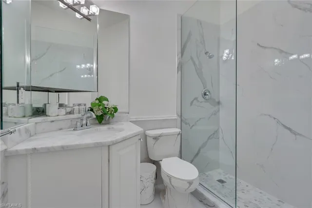 a bathroom with a granite countertop sink toilet and shower