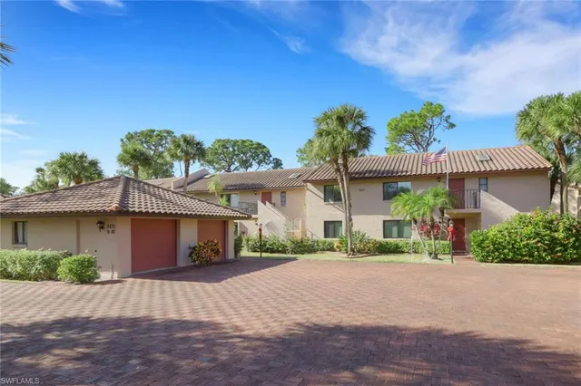 a front view of a house with a yard and potted plants
