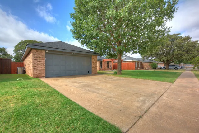 a front view of house with yard and trees in the background