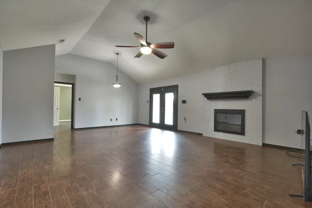 a view of empty room with wooden floor and fireplace