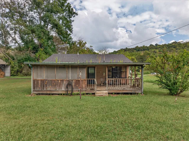 a view of a house with a yard and sitting area