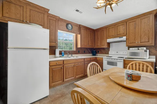 a kitchen with white cabinets and white appliances