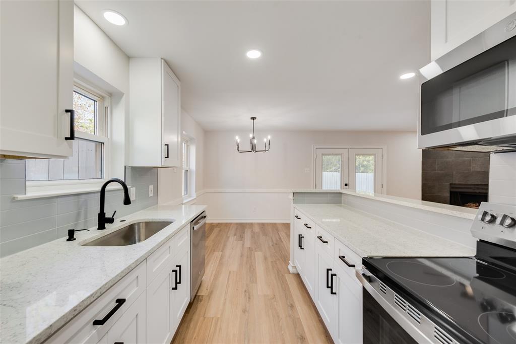 4117 Spokane Street Irving, TX 75062 - Photo 11 of 28 a large kitchen with a stove and a sink
