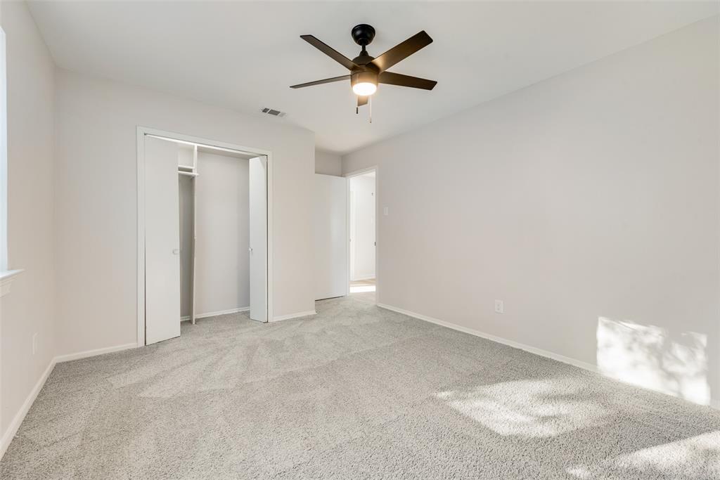 4117 Spokane Street Irving, TX 75062 - Photo 17 of 28 an empty room with chandelier fan and windows