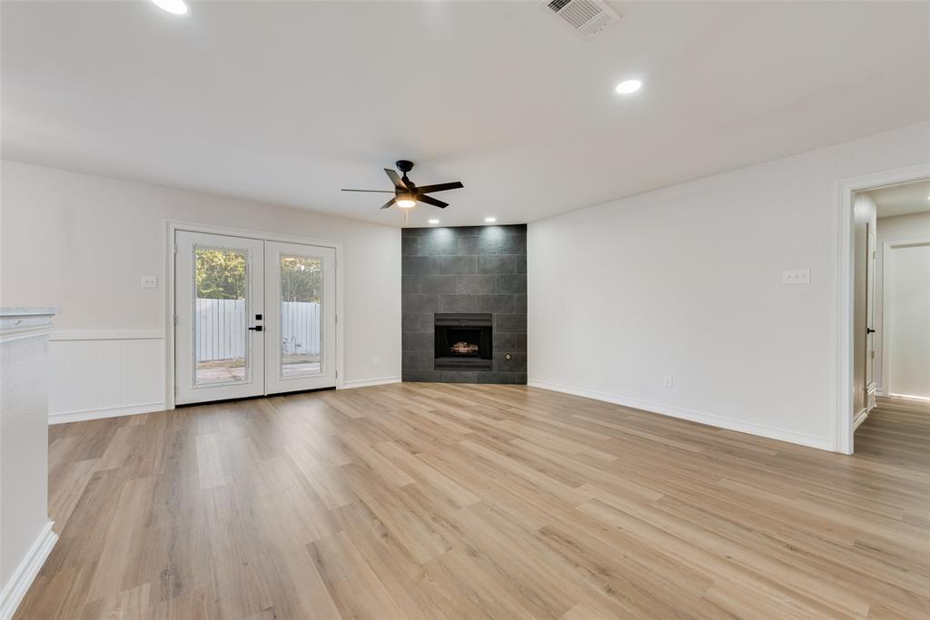 4117 Spokane Street Irving, TX 75062 - Photo 8 of 28 wooden floor in an empty room with a fireplace