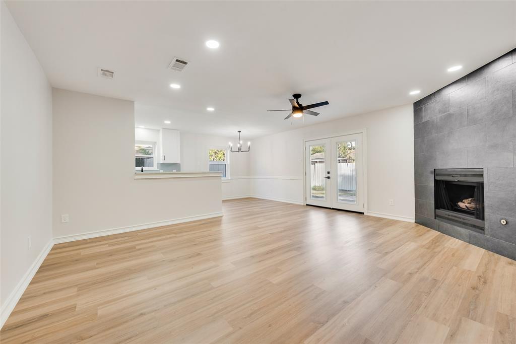 4117 Spokane Street Irving, TX 75062 - Photo 9 of 28 an empty room with a fireplace and wooden floor