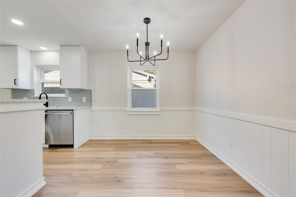 4117 Spokane Street Irving, TX 75062 - Photo 10 of 28 a kitchen with granite countertop white cabinets and wooden floor