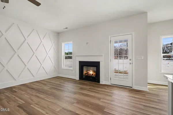an empty room with windows and fan
