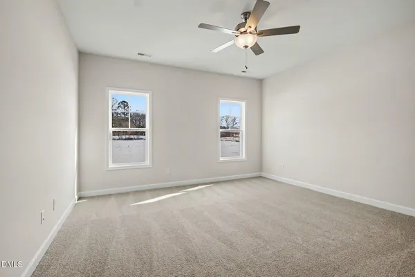 an empty room with fan and entrance