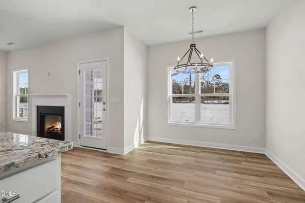 a kitchen with granite countertop kitchen island a stove a sink dishwasher and a fireplace with wooden floor