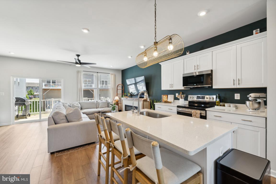 195 Presidents Pointe Avenue Ranson, WV 25438 - Photo 11 of 22 a kitchen with a stove a microwave a dining table and chairs