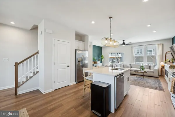 a view of a kitchen with kitchen island a stove a refrigerator a sink dishwasher with a dining table and chairs