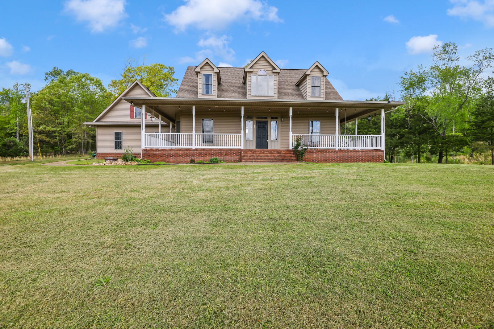a front view of a house with a garden and yard