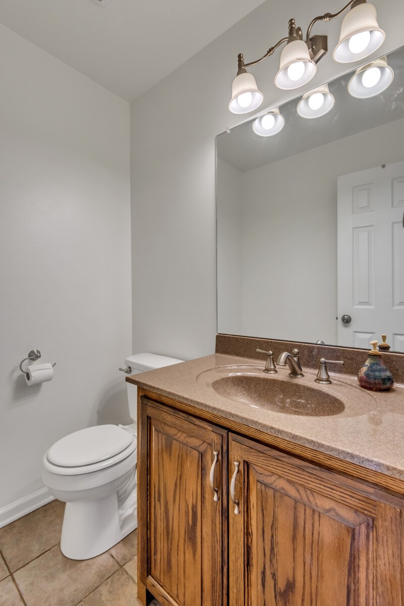 285 Heggie Road Erin, TN 37061 - Photo 24 of 50 a bathroom with a granite countertop sink a toilet and a mirror