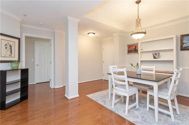 a dining room with wooden floor a chandelier a wooden table and chairs