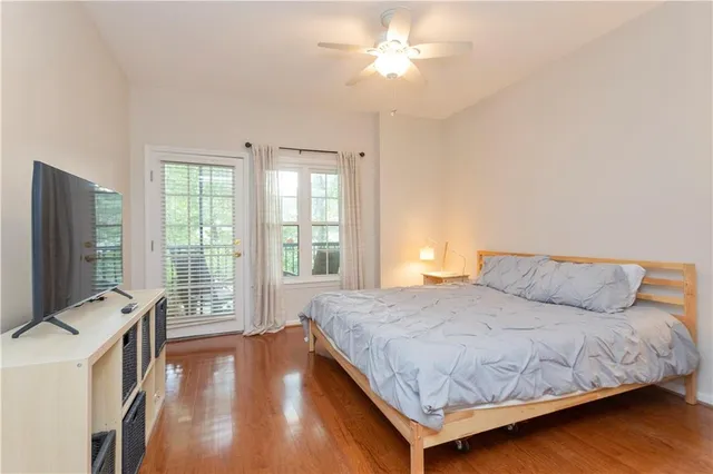 a bedroom with a bed and a flat tv screen on dresser