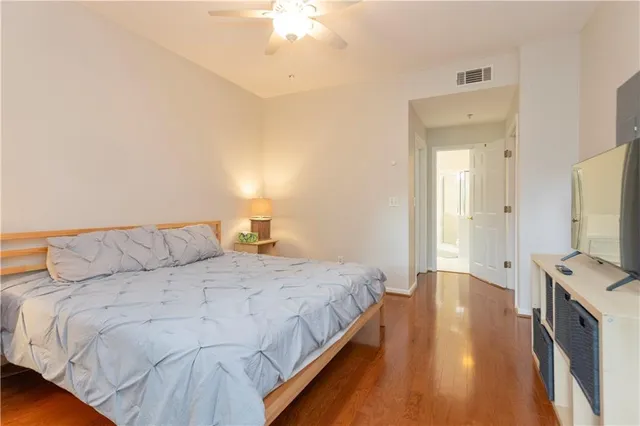 a bedroom with a bed and a flat tv screen on dresser