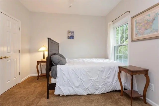 a bedroom with a bed and large windows