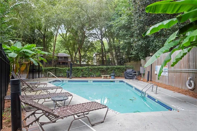 a view of backyard with swimming pool and outdoor seating