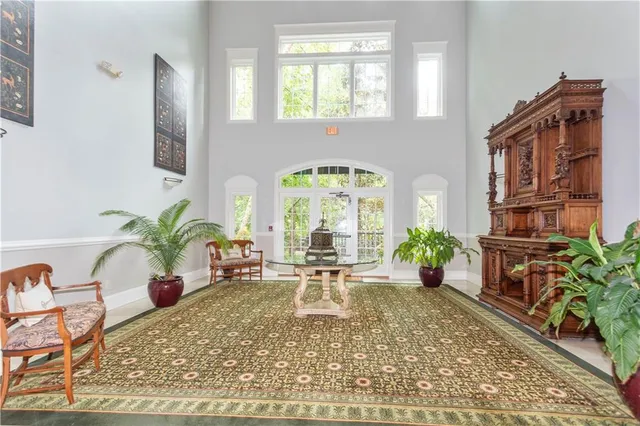 a living room with furniture flowers and a large window