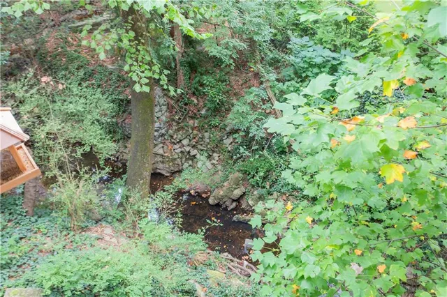 an aerial view of residential house with outdoor space and trees all around