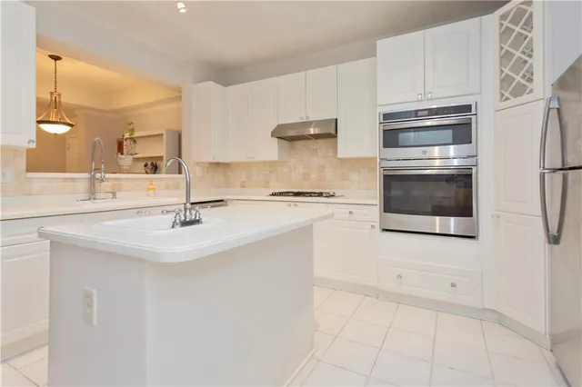 a kitchen with stainless steel appliances a sink stove and cabinets
